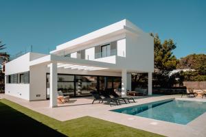 a white house with a swimming pool in front of it at s'ANDRONA in Ciutadella