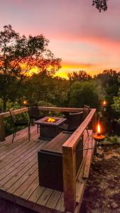 een houten terras met een vuurplaats en een zonsondergang bij Cliffside Cabin at Piney Falls - with Creek Access 