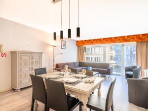 a dining room and living room with a table and chairs at Premieres Loges in Sint-Idesbald
