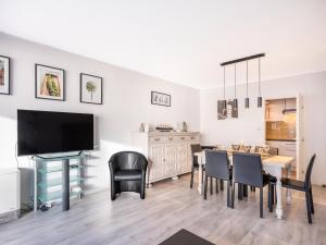 a dining room with a table and chairs and a television at Premieres Loges in Sint-Idesbald