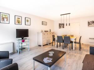 a living room with a table and a tv at Premieres Loges in Sint-Idesbald +10 photos