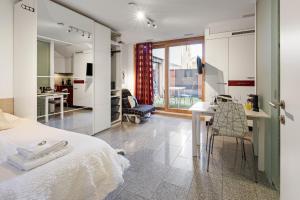 a bedroom with a bed and a kitchen with a table at Bergstudio I Flims I Laax I Ski I Caumasee in Flims