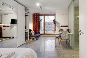 a room with a bed and a kitchen with a table at Bergstudio I Flims I Laax I Ski I Caumasee in Flims