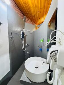 um banheiro com chuveiro e pia branca em Rice Rice Villas em Tissamaharama