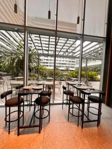 a dining room with tables and chairs and windows at Concepcion Live in Buenos Aires