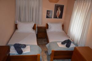 two beds in a room with towels on them at Soula's Cozy House in Kala Nera
