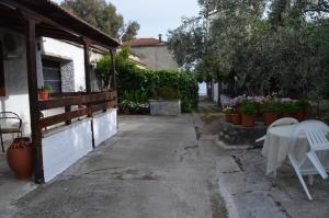 a patio with a white table and chairs next to a house at Soula's Cozy House in Kala Nera