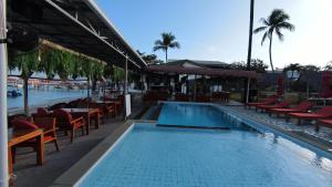 a swimming pool with tables and chairs and a restaurant at Samui Pier Beach Front & Resort in Bangrak Beach