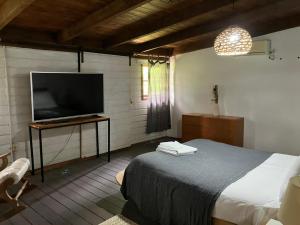 a bedroom with a bed and a flat screen tv at MUMA Hotel - Museo de la Madera in Rivera