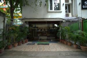 Hotel Sonali Golden Palace في بوهفانيشفار: مبنى أمامه مجموعة من النباتات الفخارية