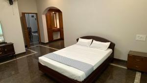 een slaapkamer met een bed met een houten hoofdeinde bij Abida Mansion 4BHK Near MCP Convention Centre IJK in Irinjālakuda