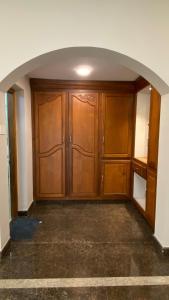 een lege kamer met houten kasten en een boogdoorgang bij Abida Mansion 4BHK Near MCP Convention Centre IJK in Irinjālakuda