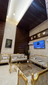 un hall avec des canapés et des tables dans un bâtiment dans l'établissement فندق الرسالةالذهبي شارع ام القري, à Aş Şafā