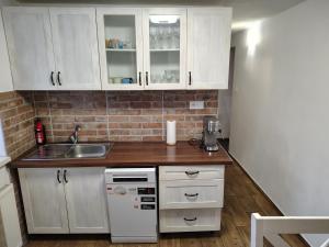 a small kitchen with white cabinets and a sink at Dušan in Vyšné Hágy