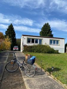 un vélo garé sur le bord d'une route devant une maison dans l'établissement Ferienwohnung am Waldesrand, à Ahlbeck