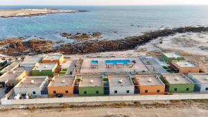 an aerial view of houses on the beach at Roushan Resort Salalah Mirbat in Mirbāţ