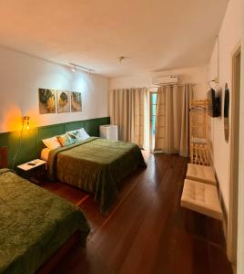 une chambre d'hôtel avec deux lits et une fenêtre dans l'établissement HOTEL MONTANAS, à Nova Friburgo