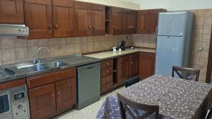 eine Küche mit Holzschränken, einem Tisch und einem Kühlschrank in der Unterkunft La casa del capitano in Tarquinia