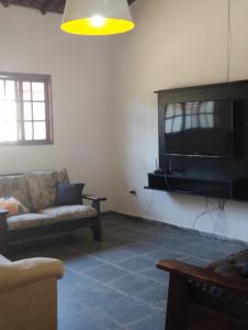 un soggiorno con divano e TV a schermo piatto di Chácara Recanto Girassol a Biritiba-Mirim