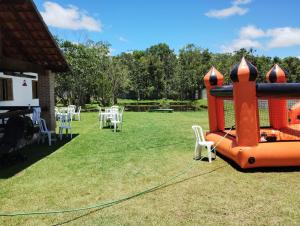 un grande gioco gonfiabile con sedie e tavoli bianchi di Chácara Recanto Girassol a Biritiba-Mirim