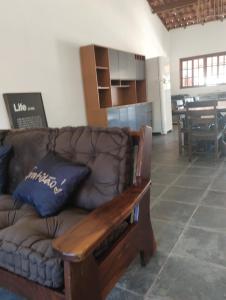 un divano in pelle marrone in un soggiorno con tavolo di Chácara Recanto Girassol a Biritiba-Mirim