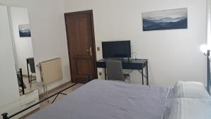 ein Schlafzimmer mit einem Bett und einem Schreibtisch mit einem Computer in der Unterkunft La casa del capitano in Tarquinia + 3 Fotos