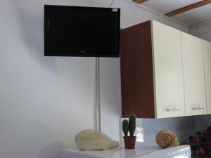 a tv hanging on a wall in a kitchen at Villaggio Camping Rancho in Cagnano Varano