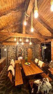 een eetkamer met een houten tafel en banken bij Eden Natural Resort - Transalpina in Căpîlna