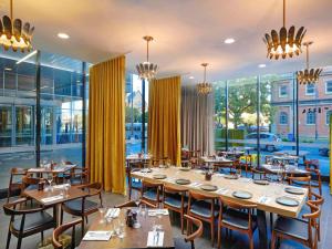 a restaurant with wooden tables and chairs and windows at Mantra Albury in Albury