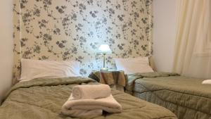a bedroom with two beds and a lamp on a table at Gran Hotel Mar del Plata in Mar del Plata