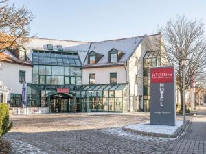 een groot gebouw met een bord ervoor bij Atomis Hotel Munich Airport by Mercure in Oberding
