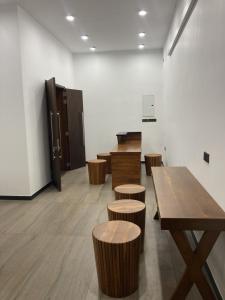 een kamer met houten tafels en krukken bij Ocean Edge Holiday Resorts in Hiriketiya