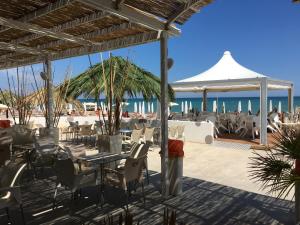 a restaurant on the beach with the ocean in the background at Residenza Ondanomala in Chieuti