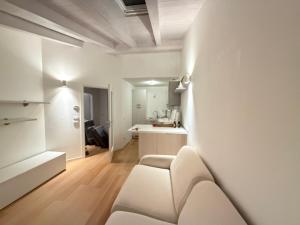 a white living room with a couch and a kitchen at La Piccola Perla di Rovereto in Rovereto