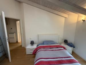 a bedroom with a bed and a white wall at La Piccola Perla di Rovereto in Rovereto +1 photo