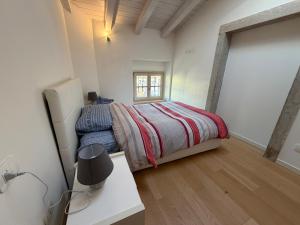 a bedroom with a bed and a desk and a window at La Piccola Perla di Rovereto in Rovereto