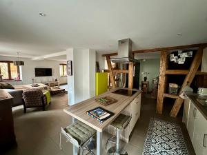 una cucina e un soggiorno con un tavolo e un divano di Loft à colombages "1789" - 80m2 a Innenheim