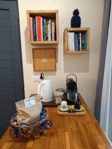 蓬塔德尔加达Cantinho da Luz的厨房柜台配有咖啡机和书籍