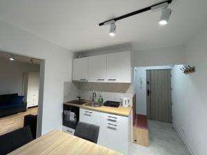 een keuken met witte kasten en een tafel in een kamer bij Zacisze Ludowa in Olecko