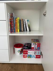 ein weißes Bücherregal mit Büchern und Kisten darauf in der Unterkunft Zacisze Ludowa in Olecko