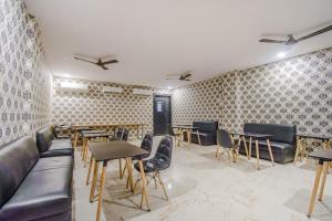 a restaurant with tables and couches and chairs at Collection O MG Guest House in Kolkata