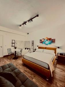 una grande camera da letto con un grande letto e un divano di Elene Suites Boutique a Palermo