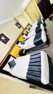 vier bedden op een rij in een kamer bij فندق درة السليمانية in Quai