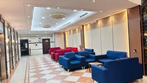 een wachtkamer met blauwe en rode stoelen bij فندق درة السليمانية in Quai