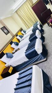 een rij bedden in een hotelkamer bij فندق درة السليمانية in Quai