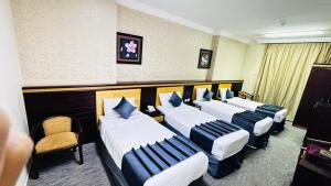 een hotelkamer met vier bedden op rij bij فندق درة السليمانية in Quai