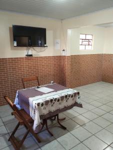een kamer met een tafel en een tv aan de muur bij Hostel da Ladeira in Ouro Preto