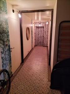 een hal die leidt naar een deur met een tegelvloer bij La Gaillote d'Or in Villers-la-Chèvre