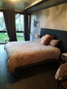 een slaapkamer met een groot bed met een groot raam bij La Gaillote d'Or in Villers-la-Chèvre