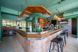 a restaurant with a bar with stools in it at Hotel el kaoba in Cabarete